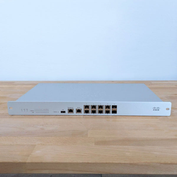 Cisco networking equipment on a wooden surface, front view showing ports and indicators.