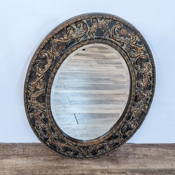 Reperch brand oval mirror with an intricately carved wooden frame on a wooden floor against a white background.