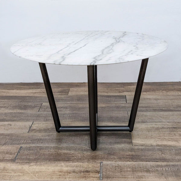 Mitchell Gold Bob Williams modern dining table with a white marble top and X-shaped polished stainless steel base.