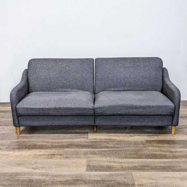 Alt text 1: Modern Dorel Home compact sofa in upright position with grey upholstery, narrow arms, and wooden tapered legs.