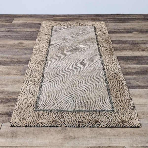 4'10" x 10'3" Reperch hand knotted rug in neutral tones, medium pile, patterned borders, on wooden floor.