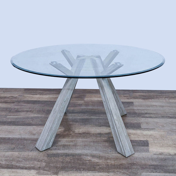 Reperch Beaumont dining table with a clear tempered glass top and sun-drenched solid acacia wood legs on a wooden floor.