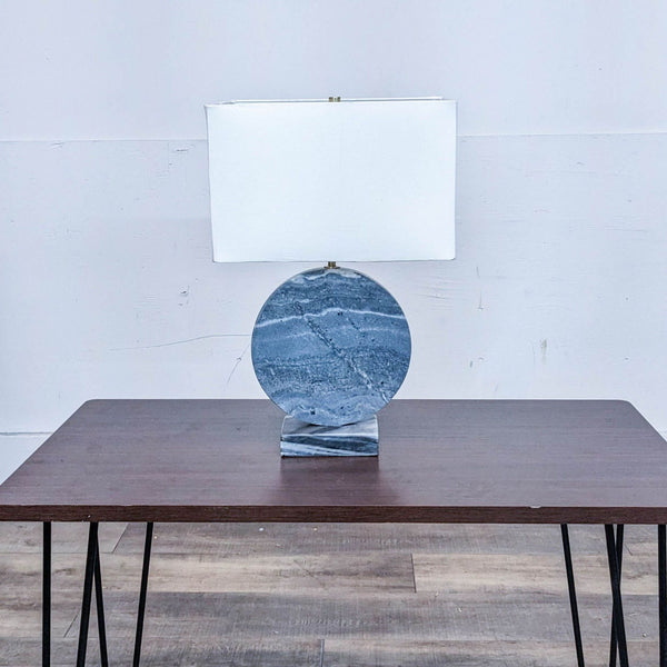 Alt text 1: Reperch brand table lamp with a textured circular marble base and a square white shade, displayed on a wooden table.