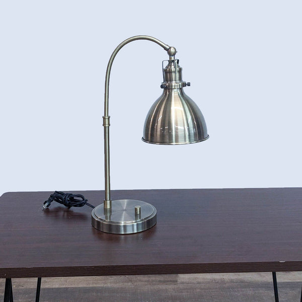 Intertek brand desk lamp with adjustable gooseneck, dome shade, and metal finish, on a wooden table.