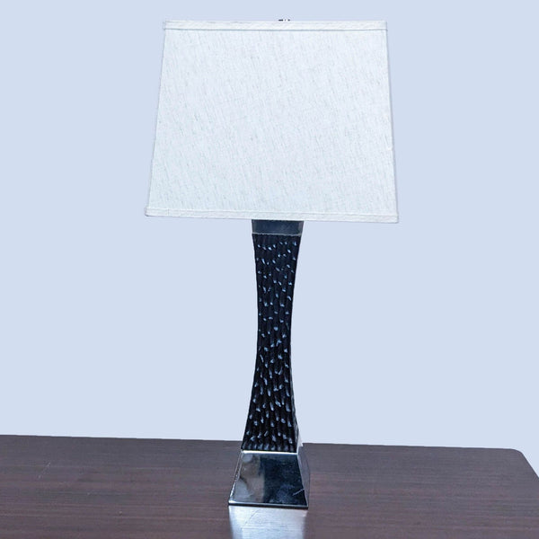 Reperch branded table lamp with a textured black base and a square white shade on a wooden table.
