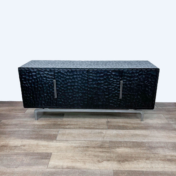 Alt text 1: Blackened mango wood credenza by Mermelada Estudio with a carved, molded effect and a stainless steel base, featuring a cord management system.