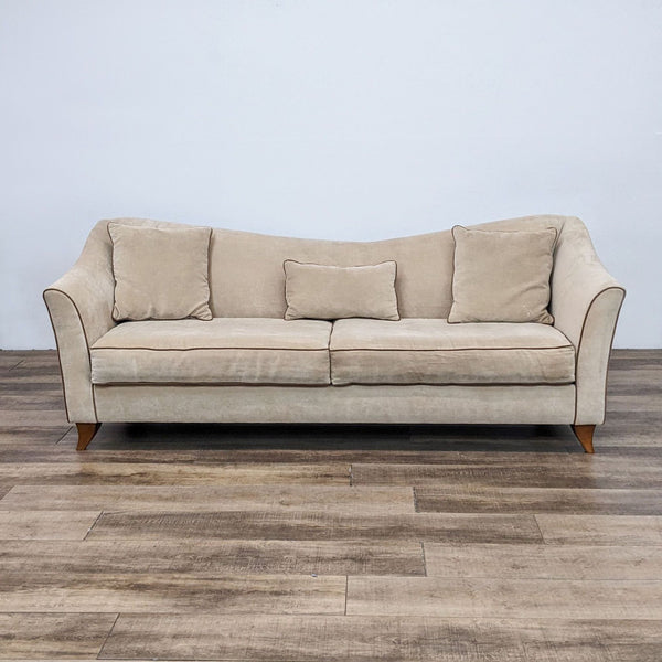 Reperch 3-seat fabric sofa with curved back, contrasting piping, and wooden feet, set on a wood floor.