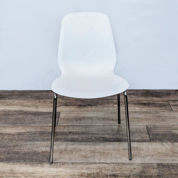 IKEA Broringe white side chair with ergonomic seat and chrome-finished metal tubular legs, showcasing modern design.