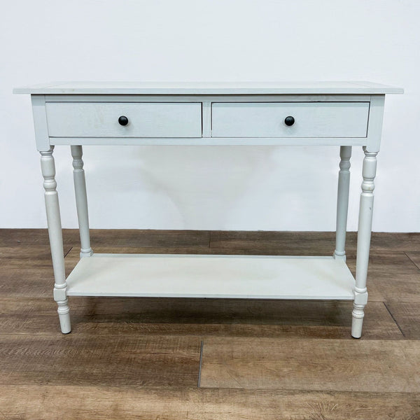 Alt text 1: Light gray Reperch console table with two drawers and turned legs, displayed on a wooden floor against a white wall.