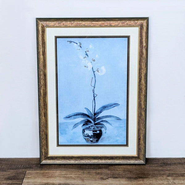 Reperch Giclee art print of a blue-toned orchid in a decorative pot within a textured frame, displayed on a wooden surface.