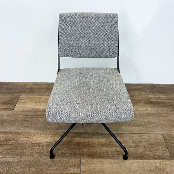 CB2 Rue Cambon office chair with a black metal frame, swivel base, and gray tweed upholstery, on a wood floor.