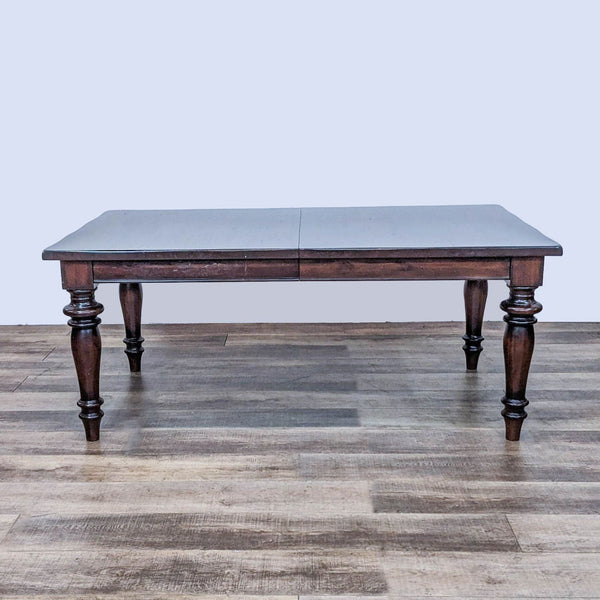 Pottery Barn Montego dining table with dark walnut finish and traditional turned legs, shown not extended.