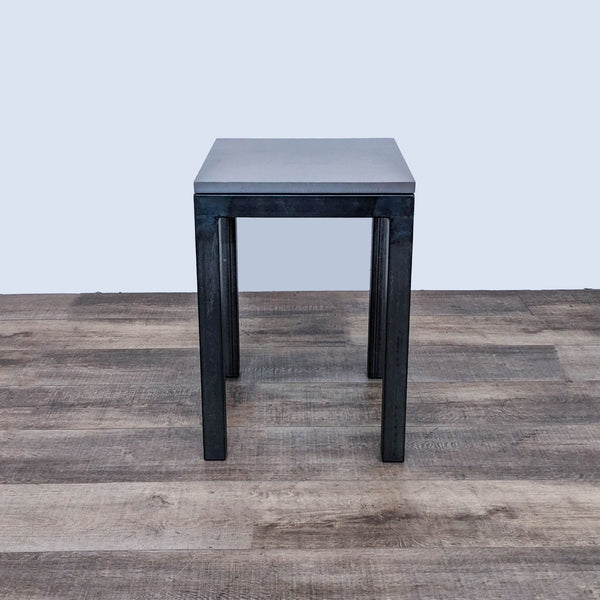Room & Board metal base side table with a simple, squared design on a wooden floor.