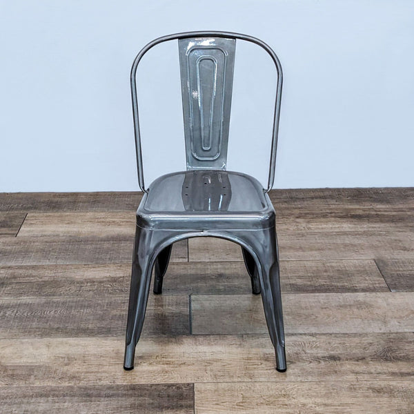 Reperch metal industrial side chair with curved back and tapered legs on wooden floor.
