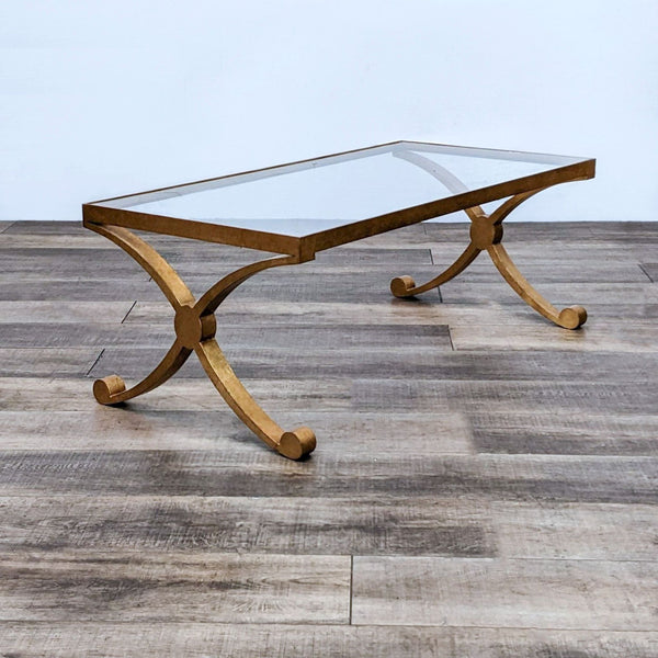 David Iatesta coffee table with a glass top on a crossed gilt metal base, showcasing elegance and modern design.