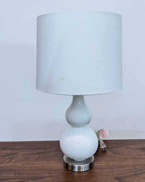 Reperch brand table lamp with a white fabric shade and two stacked white globes on a silver base.