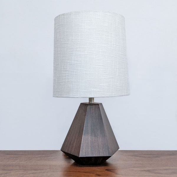 Reperch brand table lamp with a textured white shade and a geometric wooden base on a table.