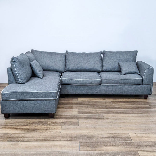 Reperch brand gray two-piece sectional with contrast piping and removable cushions, set on a wooden floor.