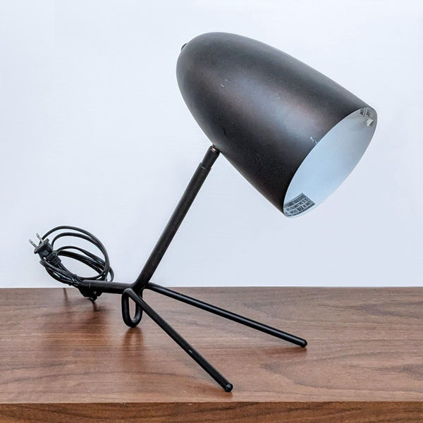 Reperch brand desk lamp with a black shade and stand, positioned on a wooden surface against a white background.