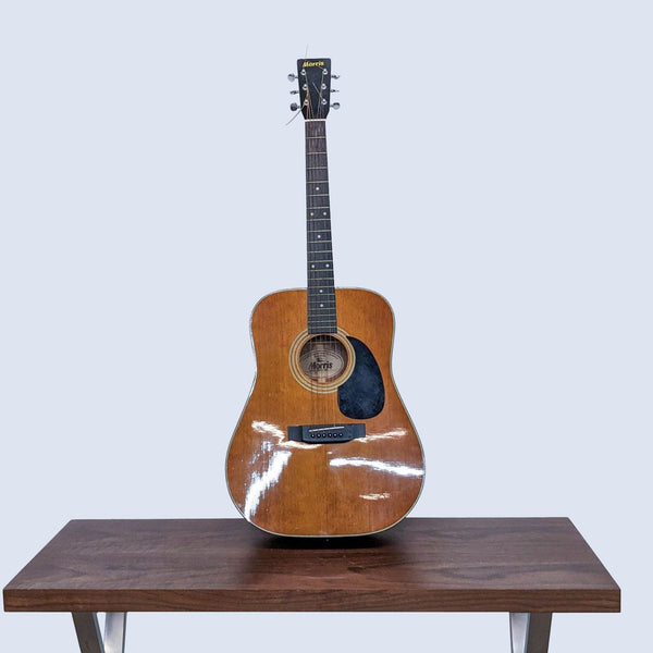Morris MD-51M acoustic guitar on wooden table against grey background, showcasing its vintage design and wood finish.