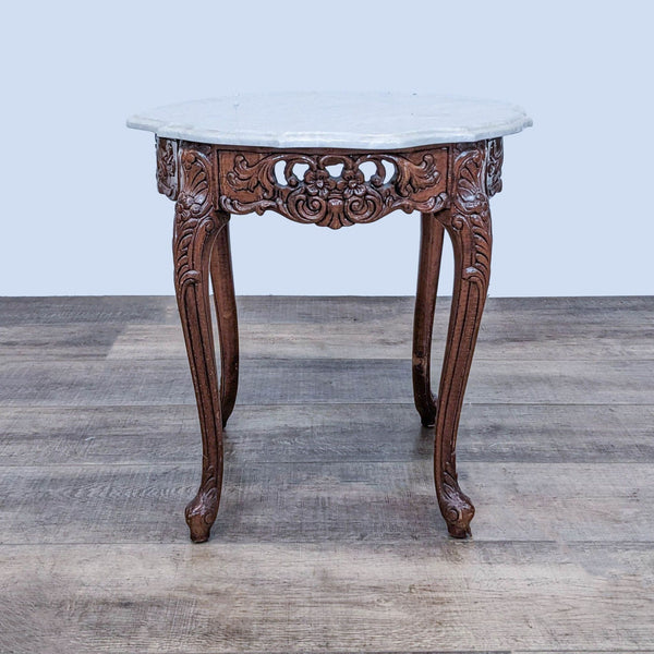 Reperch side table with a scalloped marble top and carved wooden base on a parquet floor.