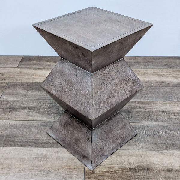 Three-tier Bassett wood table, featuring a geometric design, on a wood floor.