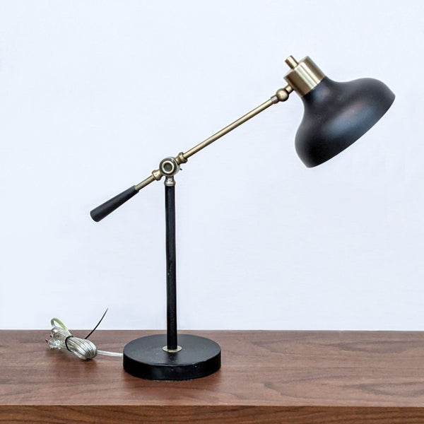 Reperch-branded vintage-style desk lamp with adjustable brass arm and black shade, showcased on wooden table.
