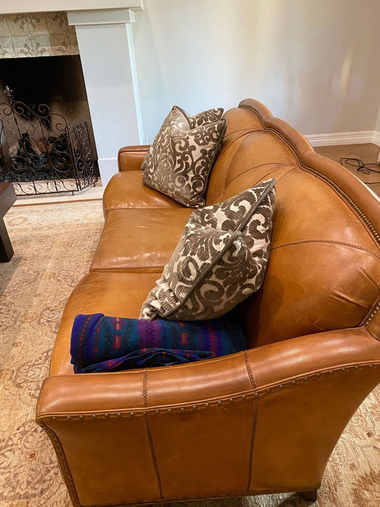 a brown leather couch with a black leather chair 