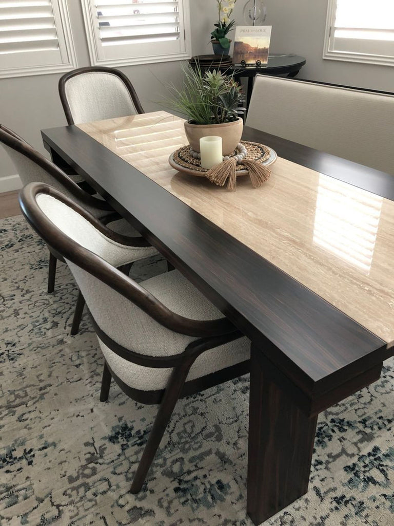 2. Close-up of marble inlay dining table by Reperch with neutral fabric chairs and tabletop decor.