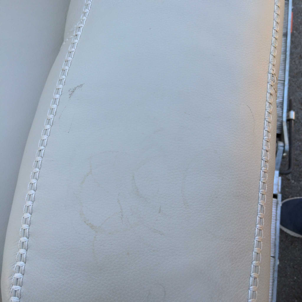 3. Armrest of a Reperch loveseat with visible scuff marks and stitching detail on light material.