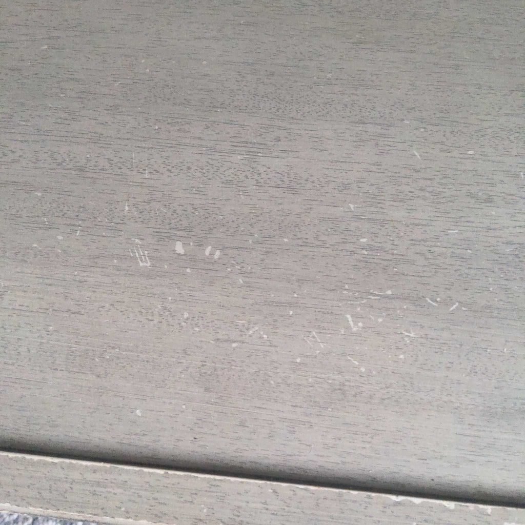 Close-up of Reperch coffee table surface showing visible wear, scratches, and paint marks on the wood.