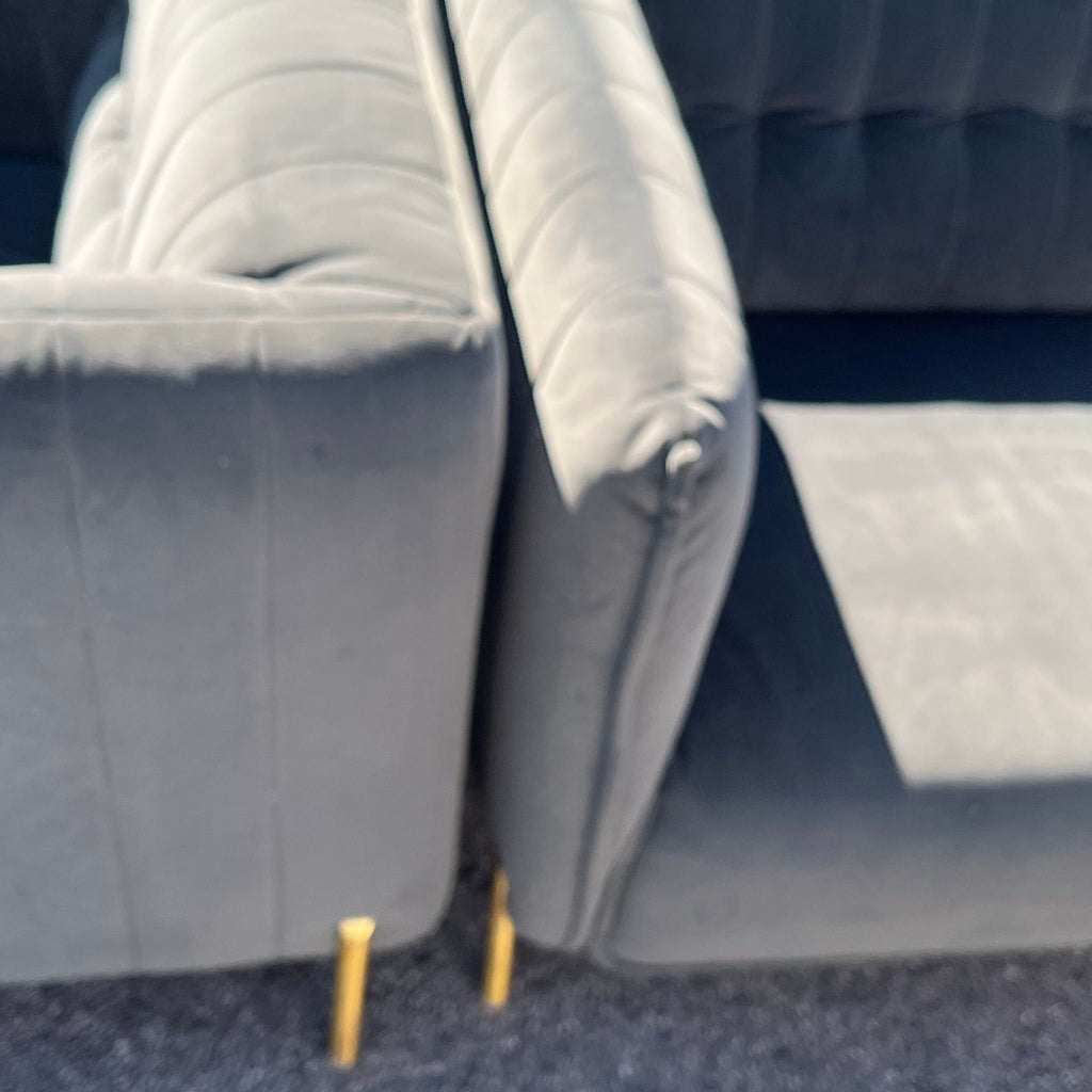 2. Side view of gray lounge sofas with gold legs, showing plush tufted upholstery outdoors.