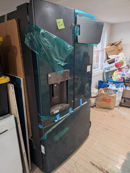 1. Reperch Refrigerator with protective film and taped corners, placed in a cluttered room, marked for sale.