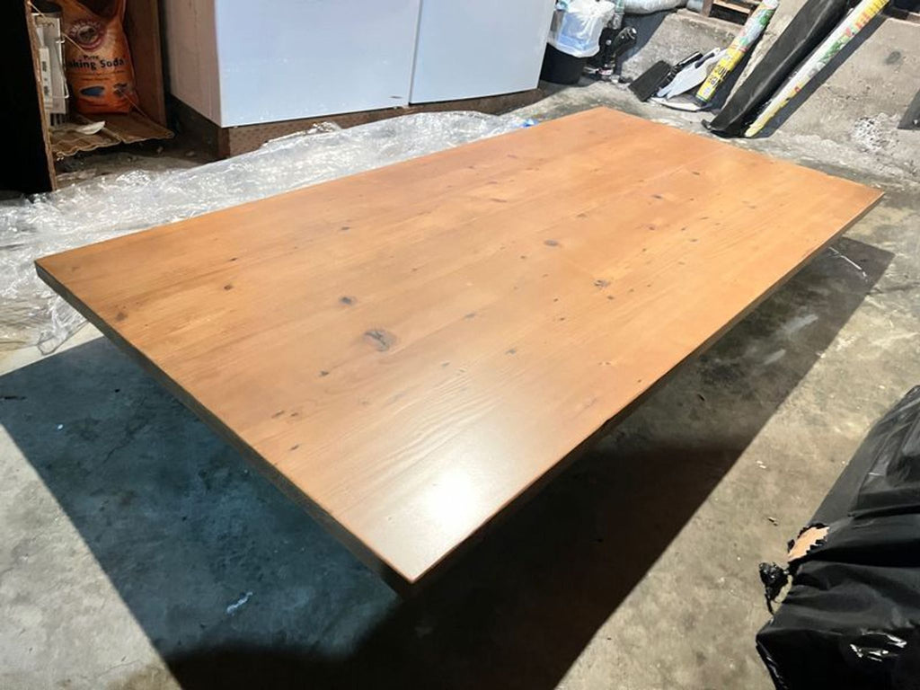 3. Angled view of a Reperch dining table, showcasing smooth wood surface and durable build in workshop.