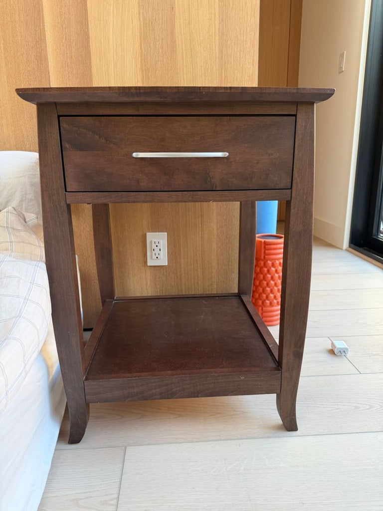 1. Reperch end table in dark wood with a single drawer, sleek handle, and lower shelf against a wooden wall.  