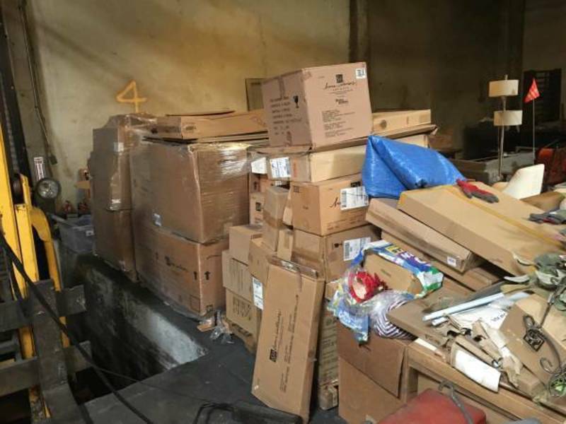 3. Piles of Reperch boxes, some with loose items on top, sit in a storage area labeled with a yellow number 4.