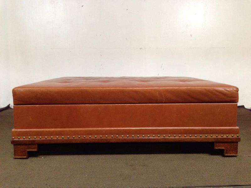 2. Square Reperch coffee table in brown leather, features geometric legs, nailhead accents, and interior storage.