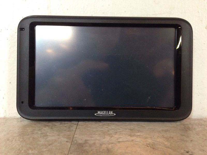 1. Magellan RoadMate 5235T-LM GPS unit with a black screen shown on a flat surface.