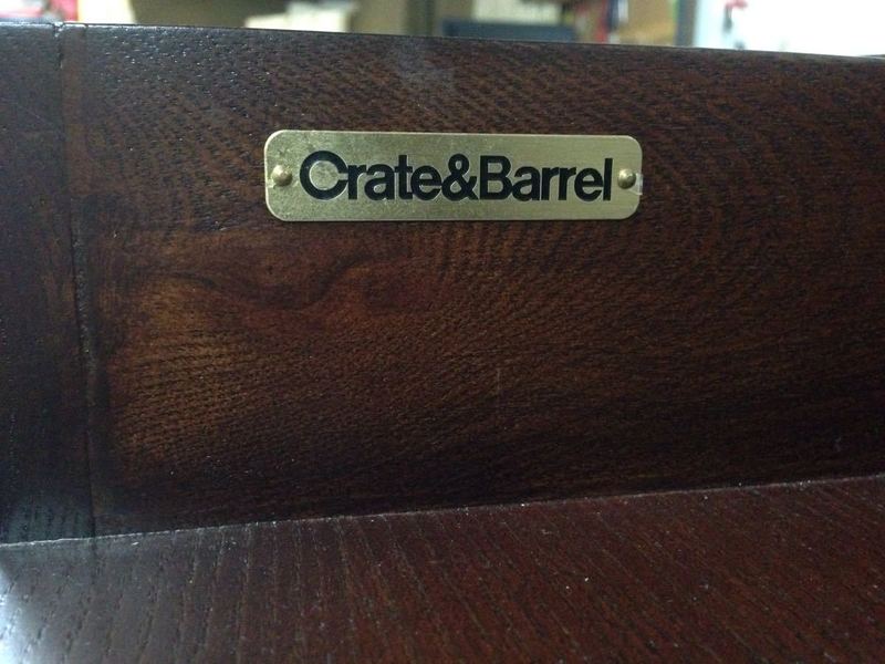 2. Close-up of a Crate & Barrel brand label attached to the wood surface of an entertainment center.