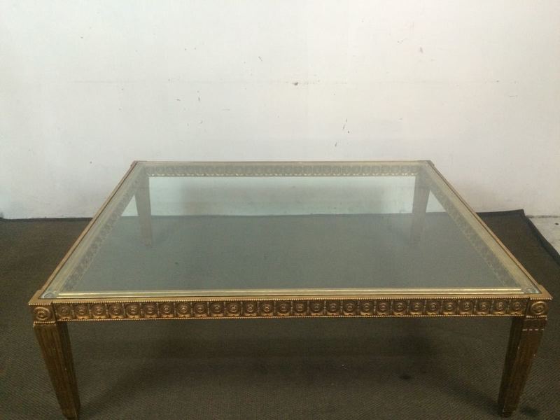 1. Square Reperch coffee table with glass top and ornate rosettes along the gold-toned edge.
