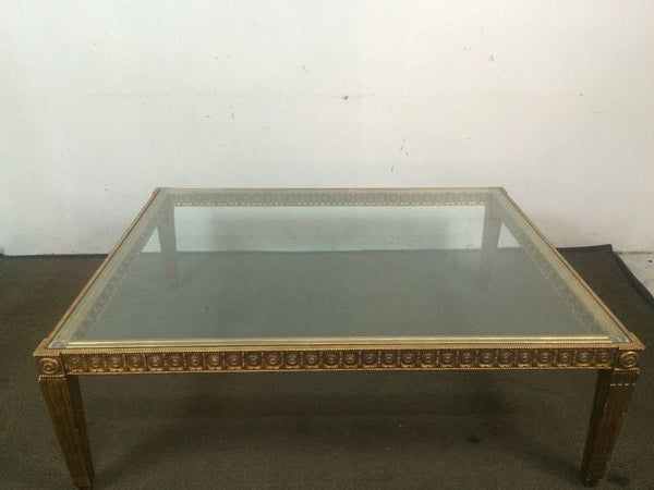 1. Square Reperch coffee table with glass top and ornate rosettes along the gold-toned edge.
