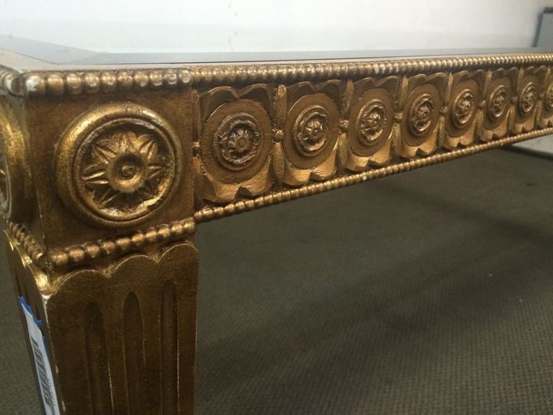 3. Close-up of Reperch coffee table edge, showing intricate rosette carvings and gold finish.