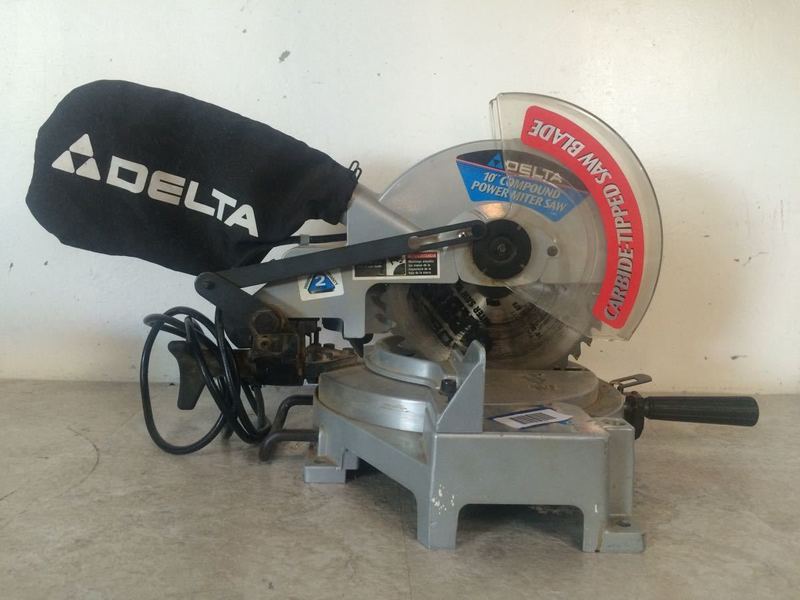 1. Delta 10" compound power miter saw with labeled parts, dust bag, and visible blade, shown on a work surface.