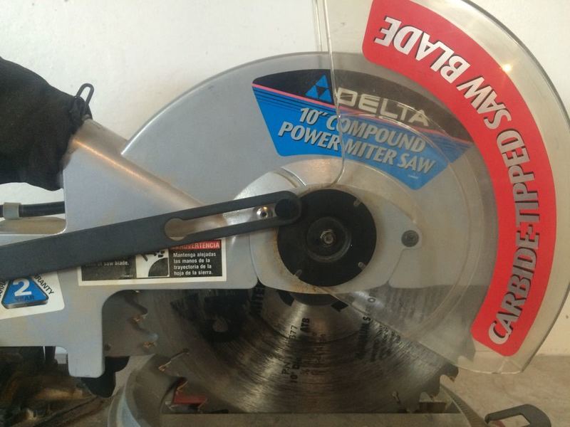 3. Detailed view of the Delta 36-075 saw blade area, featuring carbide-tipped blade and safety cover labels.
