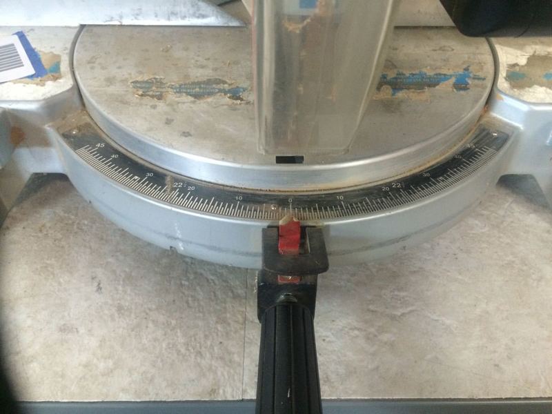 2. Close-up of Delta miter saw base, showing the angle adjustment gauge and pivot handle for precise cutting.