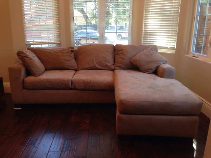 2. A beige Reperch sofa featuring chaise, two pillows, and wood feet, in a sunlit living room.  