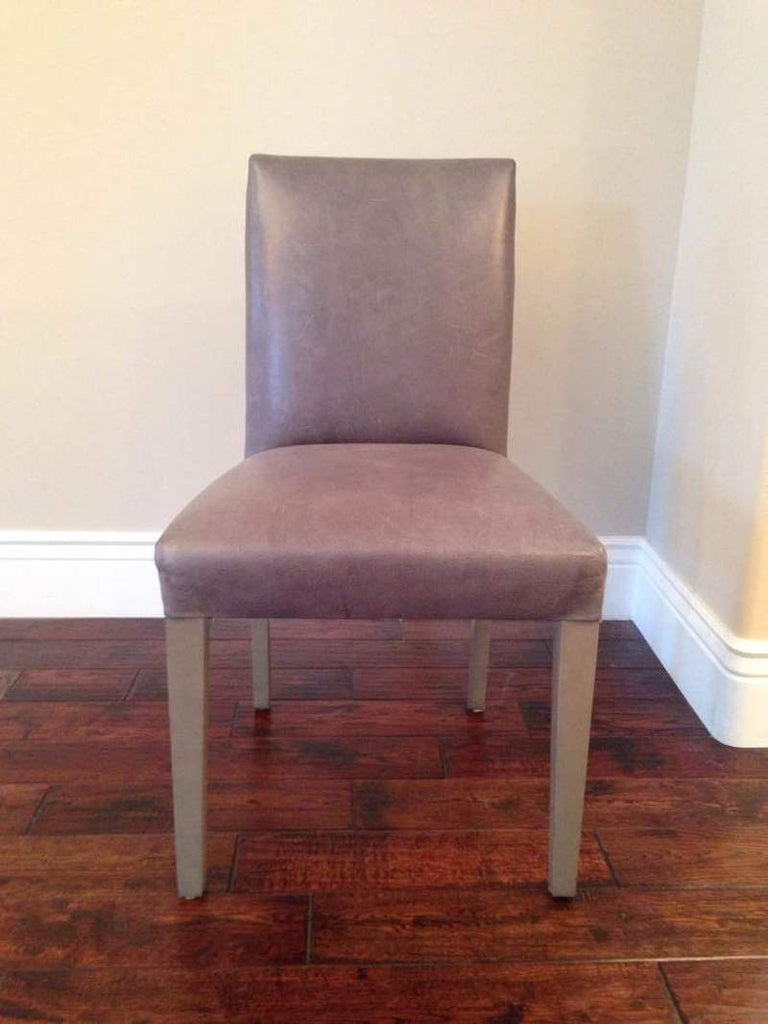 1. Reperch chair with bearing wood legs, upholstered in grey fabric, shown frontally on hardwood floor.