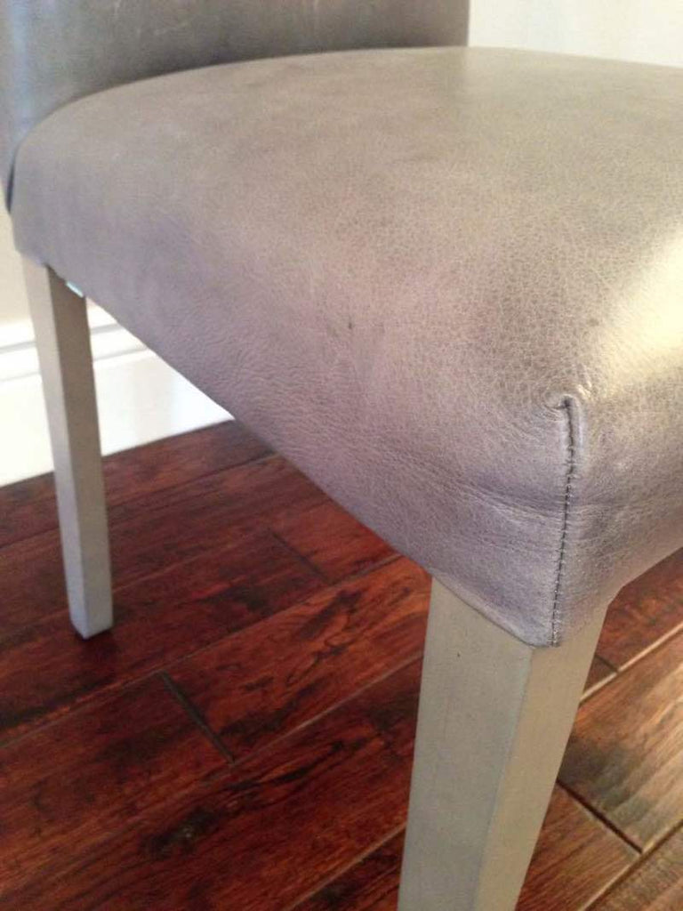 3. Close-up of the Reperch chair’s padded seat and wooden leg, highlighting its bearing wood construction.