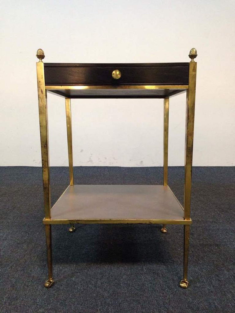 1. Reperch side table with gold metal frame, a dark wood drawer, and decorative finials on each corner.  