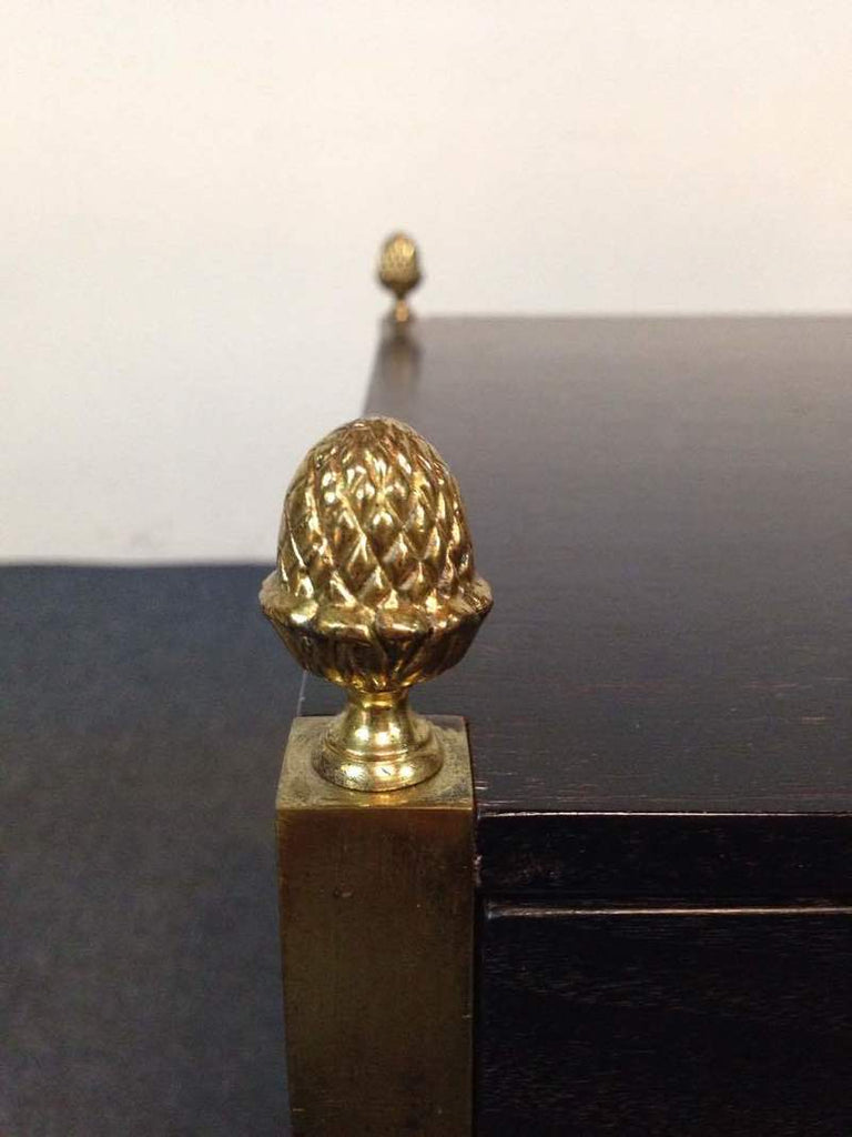 3. Close-up of Reperch table's gold finial detail on the corner of the dark wood top.